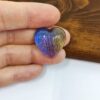 Cabochon artigianale in resina, imitazione di labratodite a forma di cuore, colori blu, viola, oro, grigio.